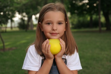 Photo of Cute little girl holding water bomb in park