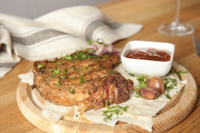 Photo of Delicious grilled pork chop served on wooden table