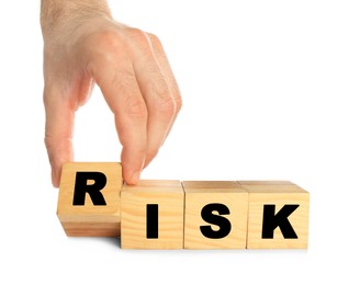 Photo of Man making word Risk of wooden cubes on white background, closeup