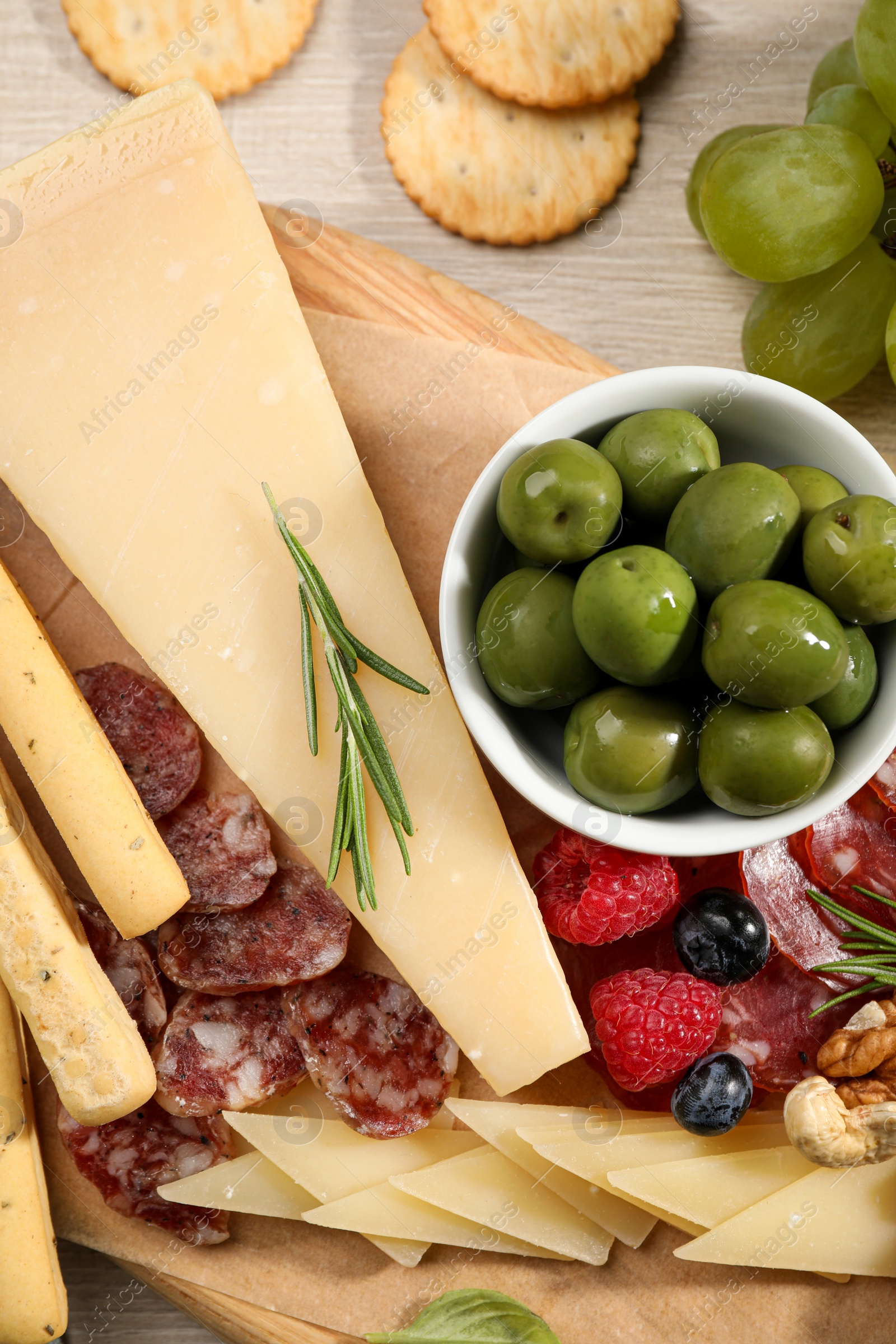 Photo of Snack set with delicious Parmesan cheese on light wooden table, flat lay