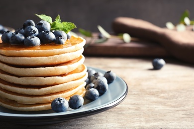 Photo of Plate with pancakes and berries on wooden table
