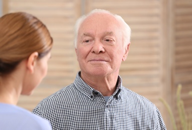 Photo of Elderly man with female caregiver at home