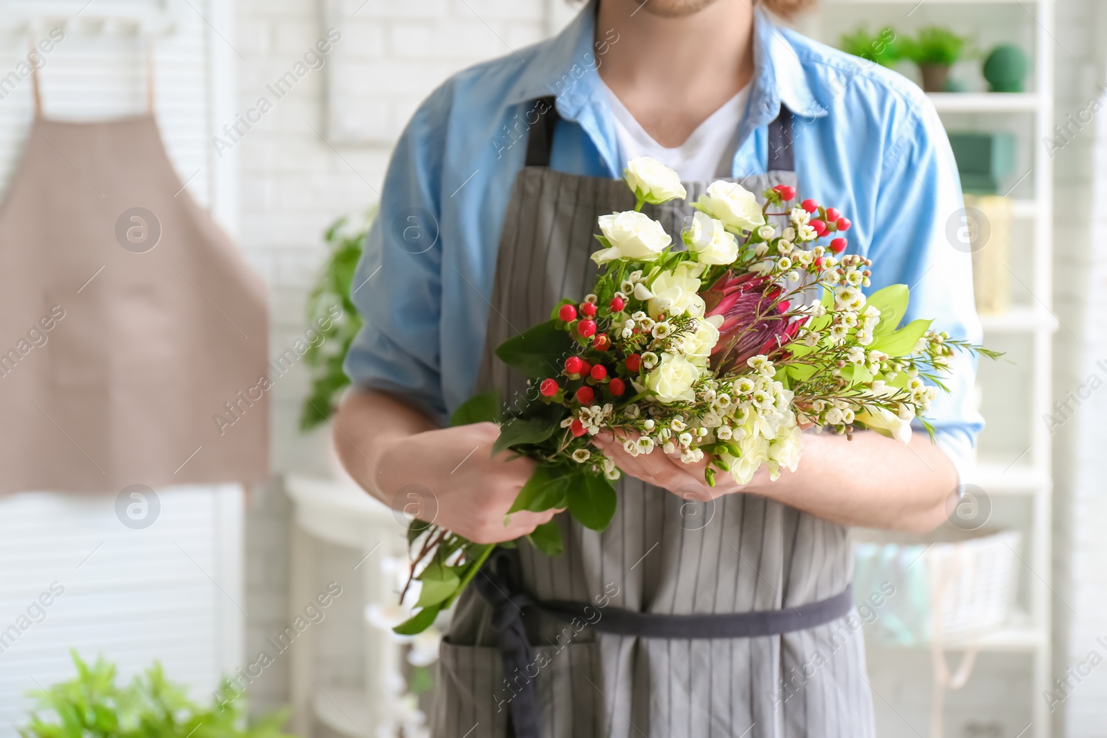 Photo of Male florist with beautiful bouquet at workplace