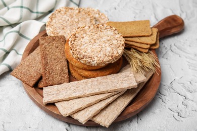 Photo of Rye crispbreads, rice cakes and rusks on white textured table