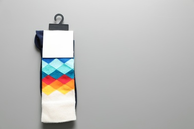 Photo of Pair of colorful socks on gray background with space for text