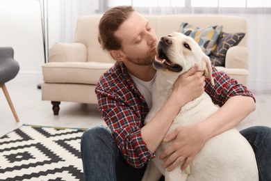 Photo of Adorable yellow labrador retriever with owner at home
