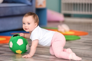 Photo of Cute baby playing with ball at home