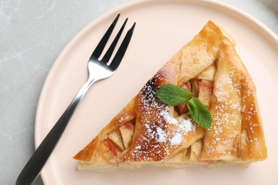 Photo of Slice of traditional apple pie on light marble table, top view