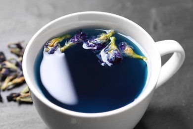 Photo of Organic blue Anchan in cup on table, closeup. Herbal tea