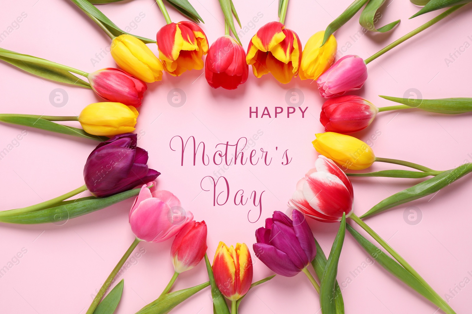 Image of Heart shaped frame made with tulips and phrase HAPPY MOTHER'S DAY on light pink background, flat lay