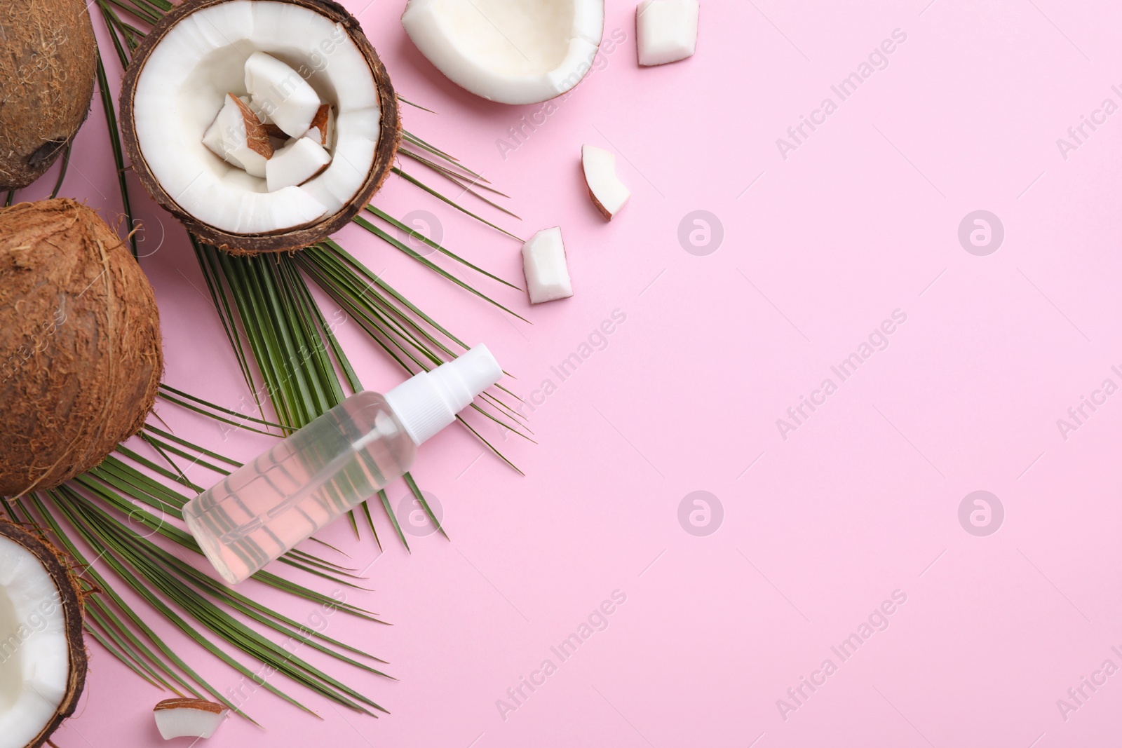 Photo of Flat lay composition with coconut oil on pink background, space for text