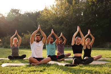 Photo of Group of people practicing yoga on mats outdoors