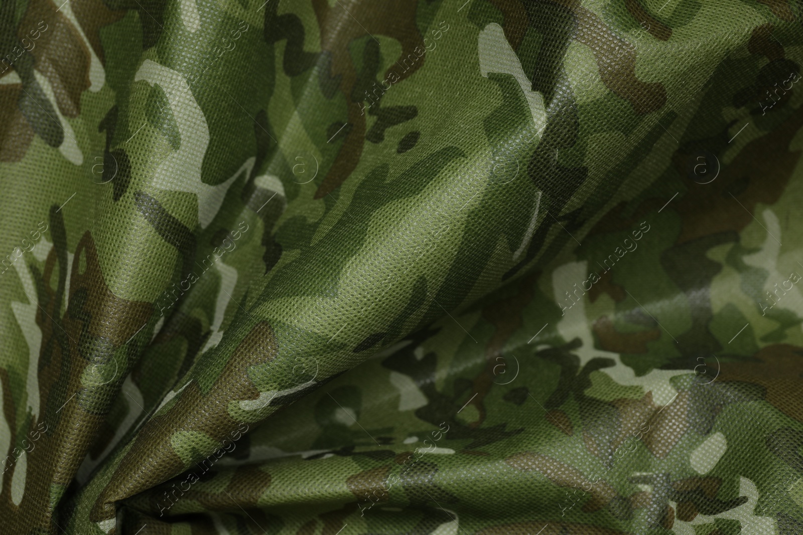 Photo of Texture of crumpled camouflage fabric as background, top view