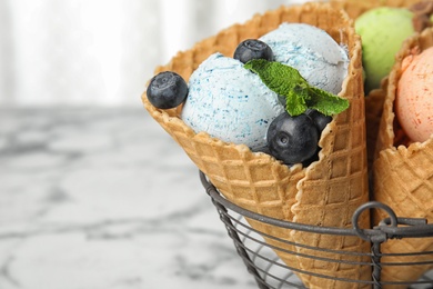 Delicious ice creams served in basket on table, closeup. Space for text