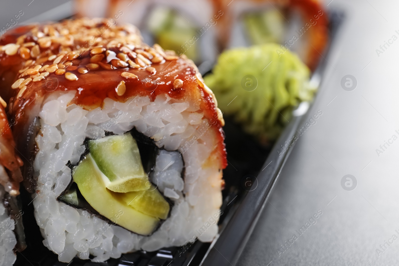 Photo of Fresh tasty sushi rolls on table, closeup with space for text. Food delivery service