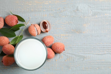 Photo of Fresh lychee juice and fruits on grey wooden table, flat lay. Space for text