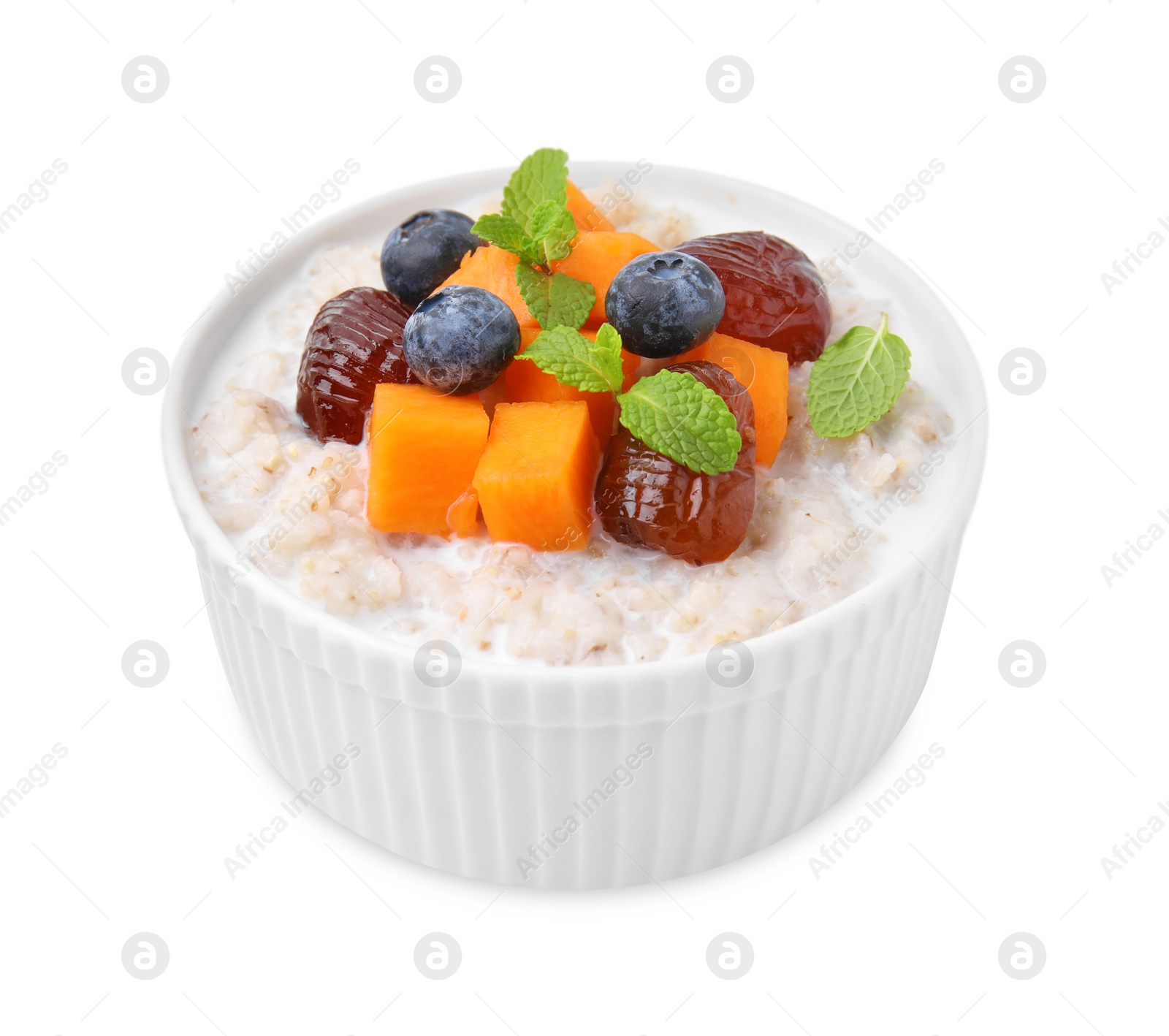 Photo of Delicious barley porridge with blueberries, pumpkin, dates and mint in bowl isolated on white