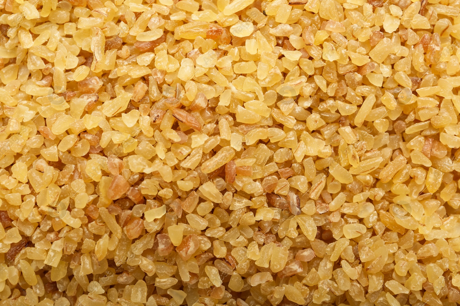 Photo of Pile of uncooked bulgur as background, top view