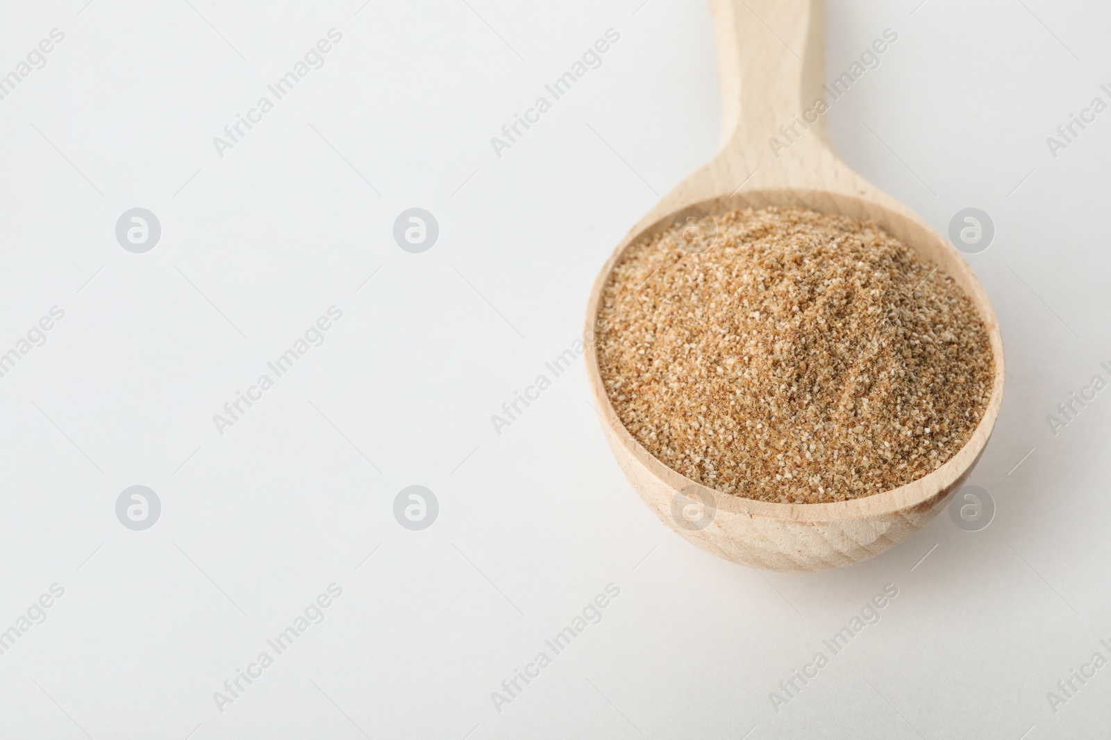 Photo of Spoon of buckwheat flour isolated on white. Space for text