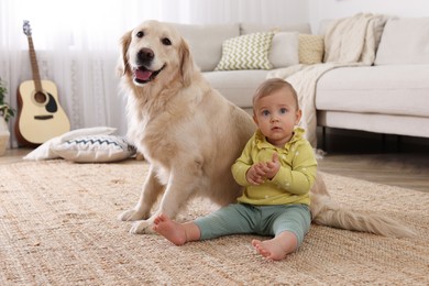 Photo of Cute little baby with adorable dog on floor at home