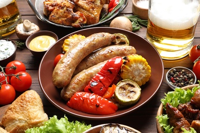 Photo of Delicious meal served for barbecue party on wooden table