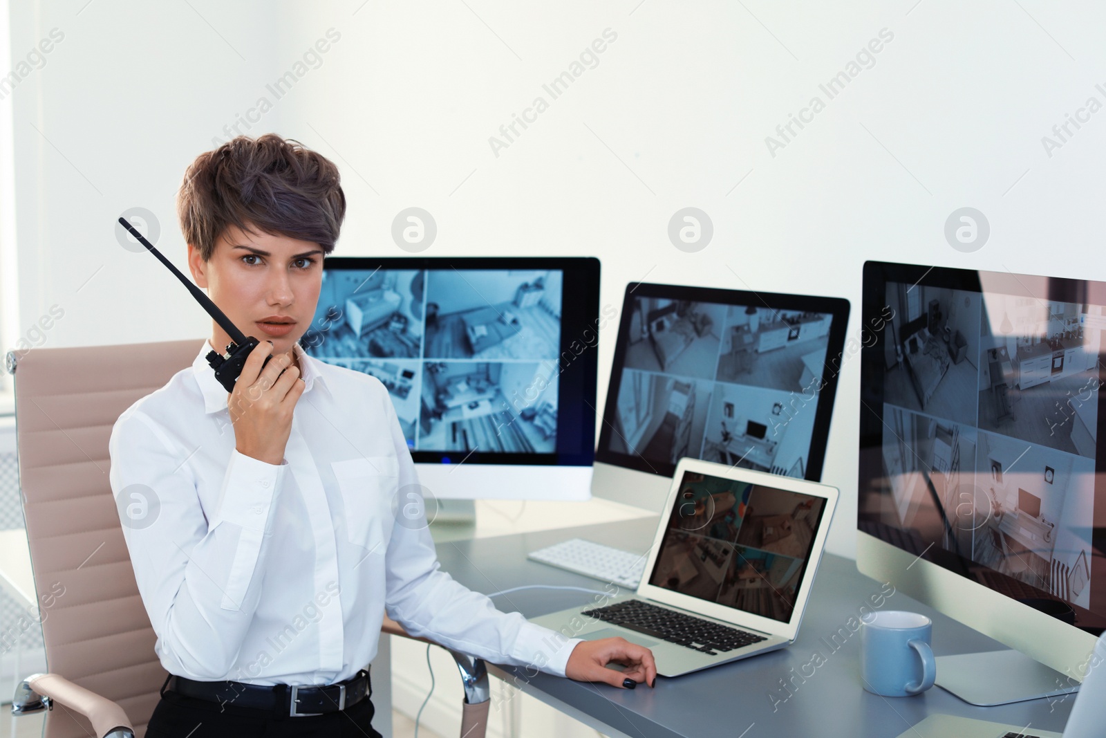 Photo of Female security guard using portable transmitter indoors