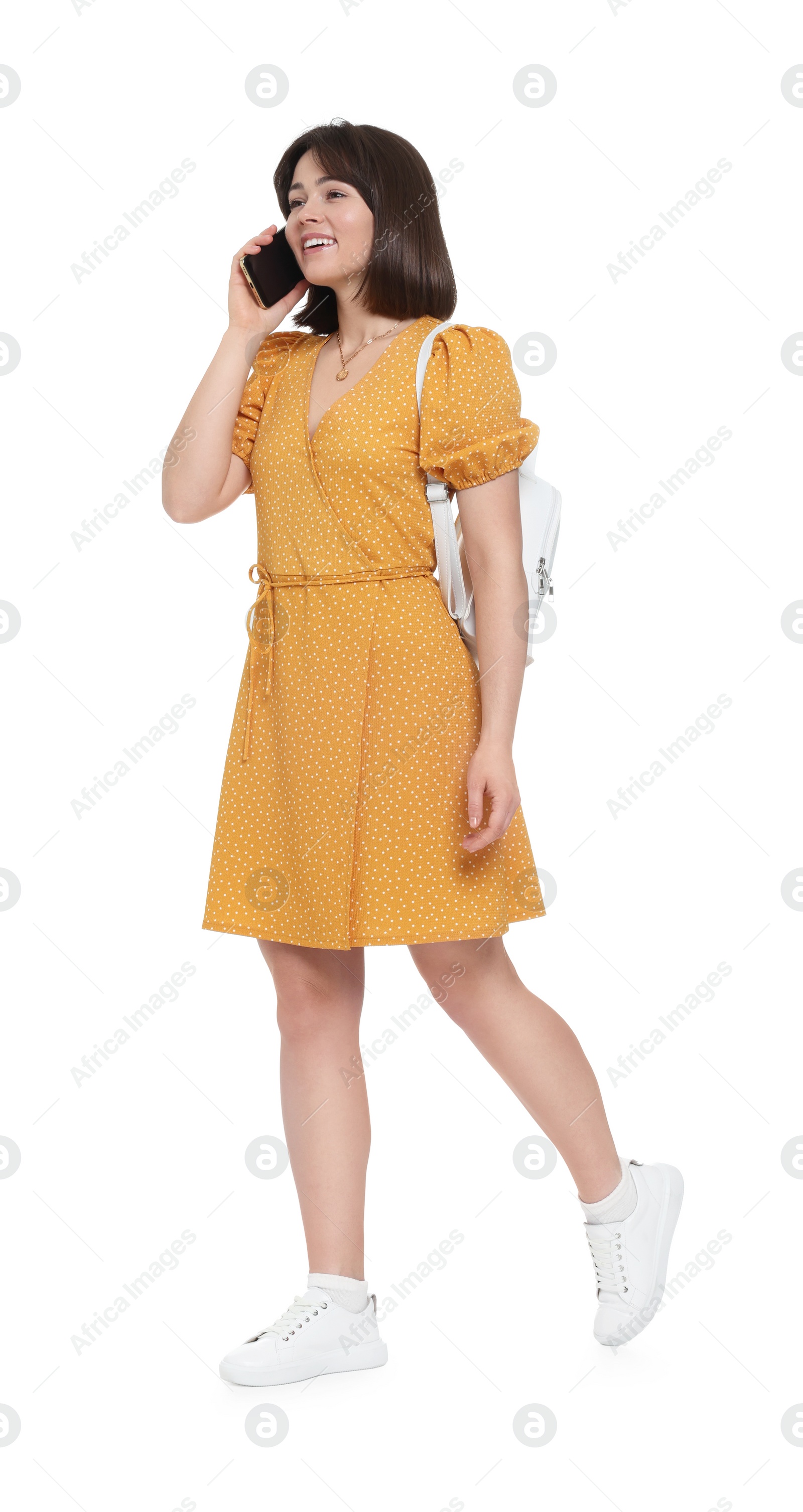 Photo of Happy woman with backpack talking on smartphone against white background