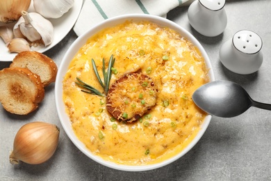 Photo of Tasty homemade French onion soup on grey table, flat lay