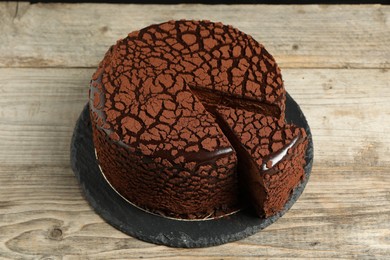 Delicious chocolate truffle cake on wooden table