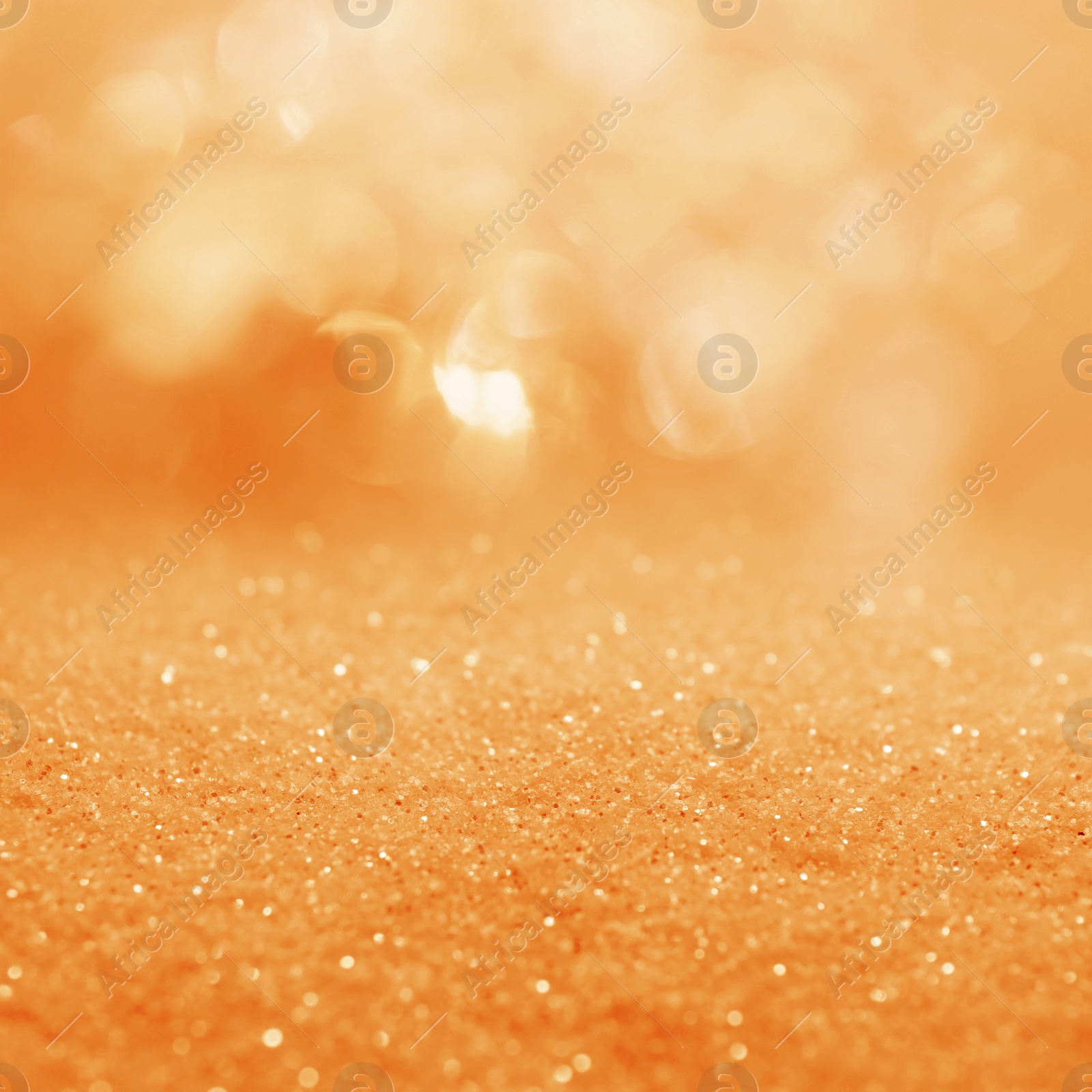 Image of Shiny orange glitter and blurred lights on background. Bokeh effect