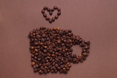 Cup of hot drink, composition made with coffee beans on brown background, flat lay