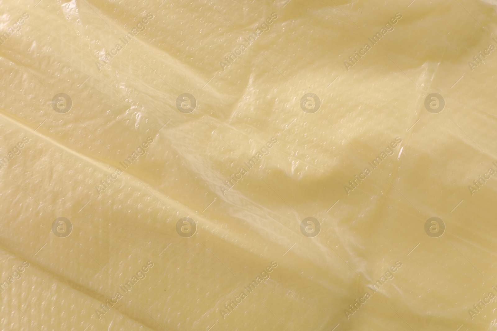 Photo of Texture of yellow plastic bag as background, closeup