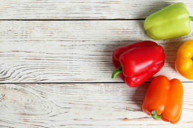 Ripe bell peppers on white wooden table, top view. Space for text