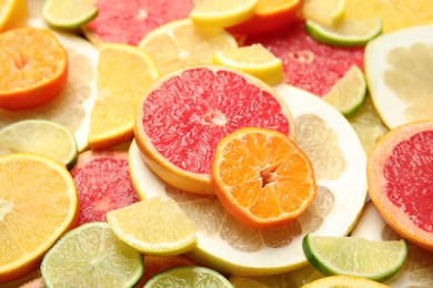 Photo of Slices of different citrus fruits as background