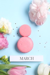 Photo of International Women's day. 8th of March made with delicious macarons and beautiful flowers on light blue background, flat lay