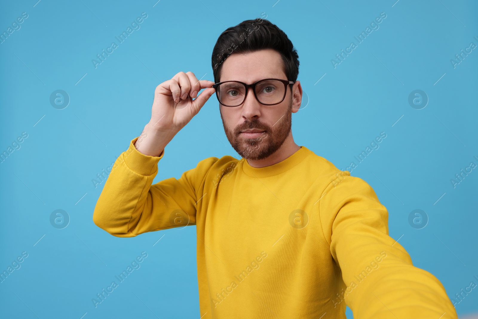 Photo of Man taking selfie on light blue background