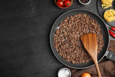 Fried minced meat served on black table, flat lay. Space for text