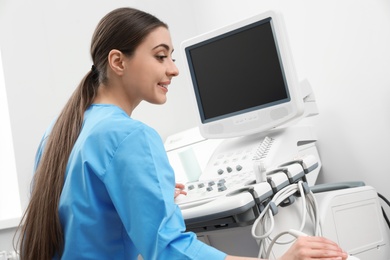 Sonographer operating modern ultrasound machine in clinic