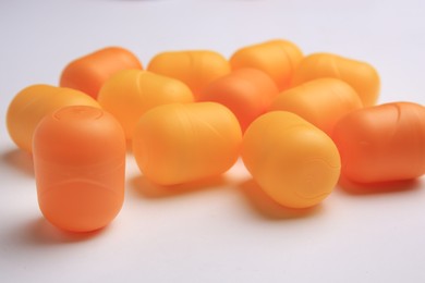 Photo of Sveti Vlas, Bulgaria - June 30, 2023: Orange plastic capsules from Kinder Surprise Eggs on white background, closeup