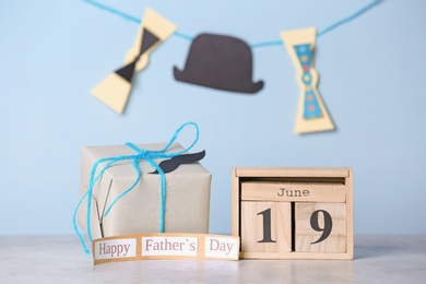 Calendar with date and gift box on table. Father's day celebration