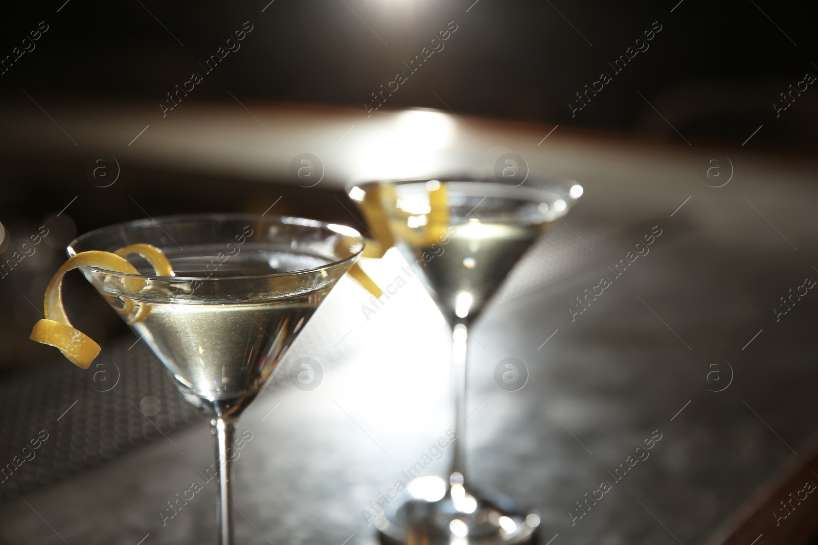 Photo of Glasses of lemon drop martini cocktail in bar, closeup. Space for text