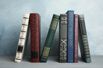 Collection of old books on grey wooden shelf