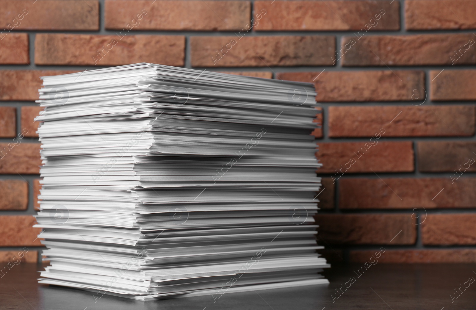 Photo of Stack of paper sheets on black table