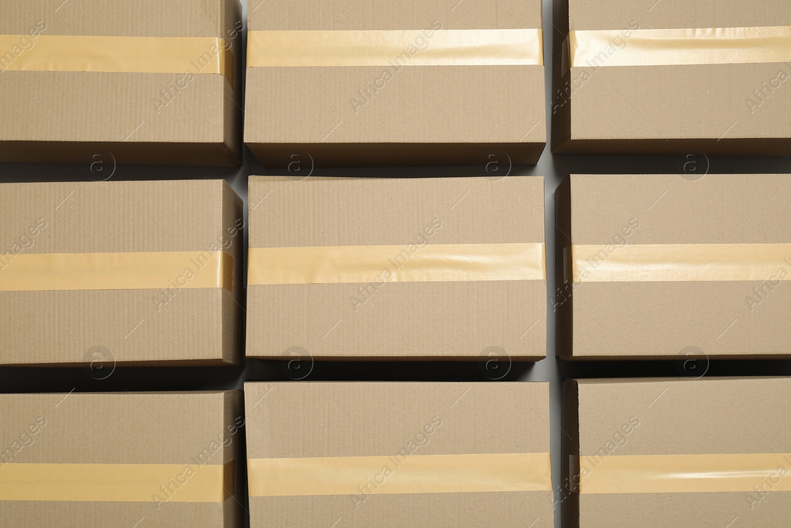 Photo of Many closed cardboard boxes with tape on light grey background, flat lay