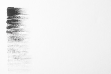 Photo of Strokes of black ink on white background, top view. Space for text