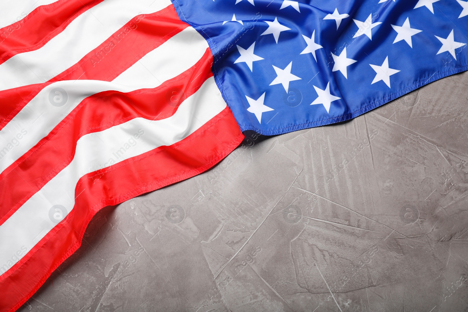 Photo of American flag on light grey background, top view. Space for text