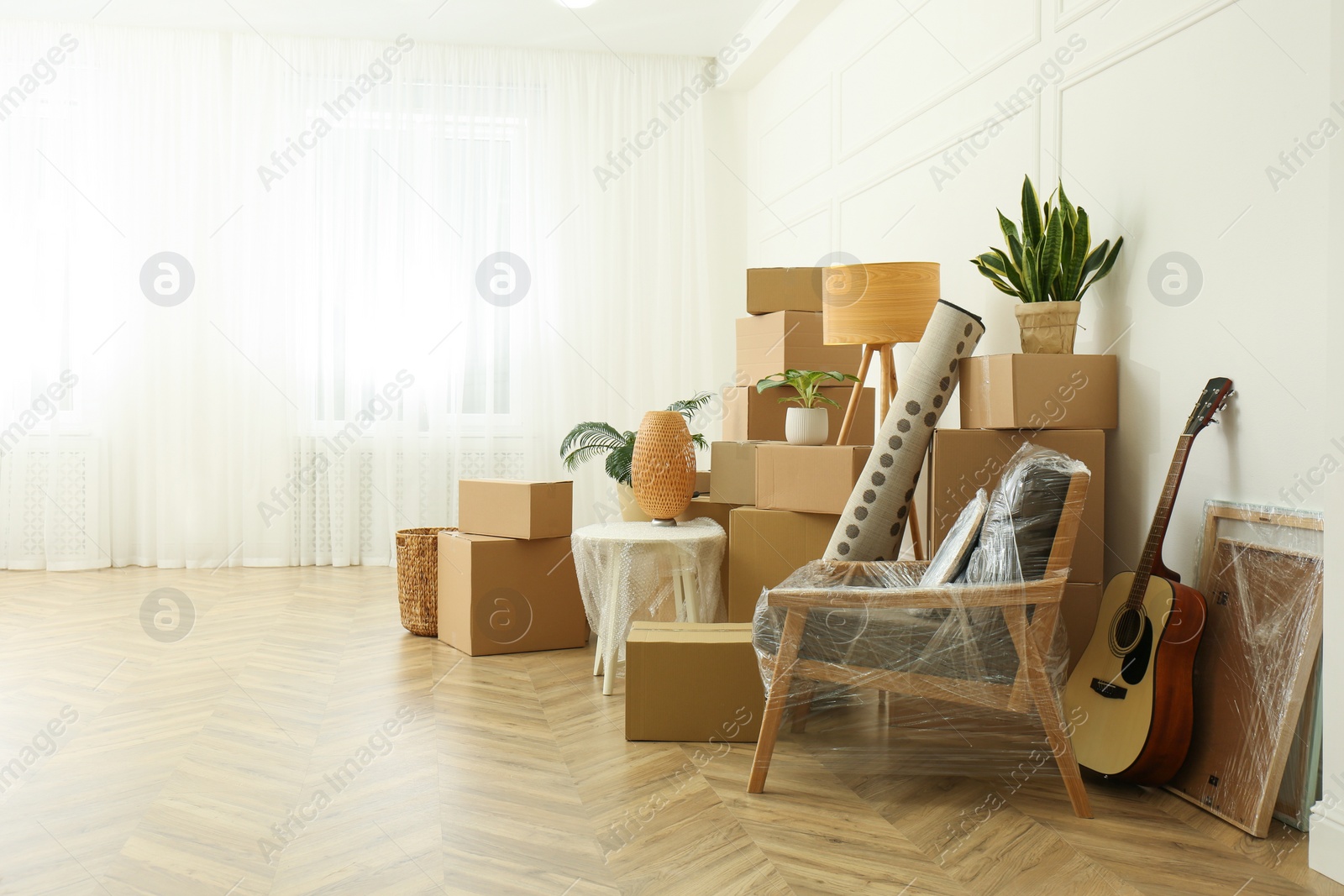 Photo of Cardboard boxes and household stuff indoors, space for text. Moving day
