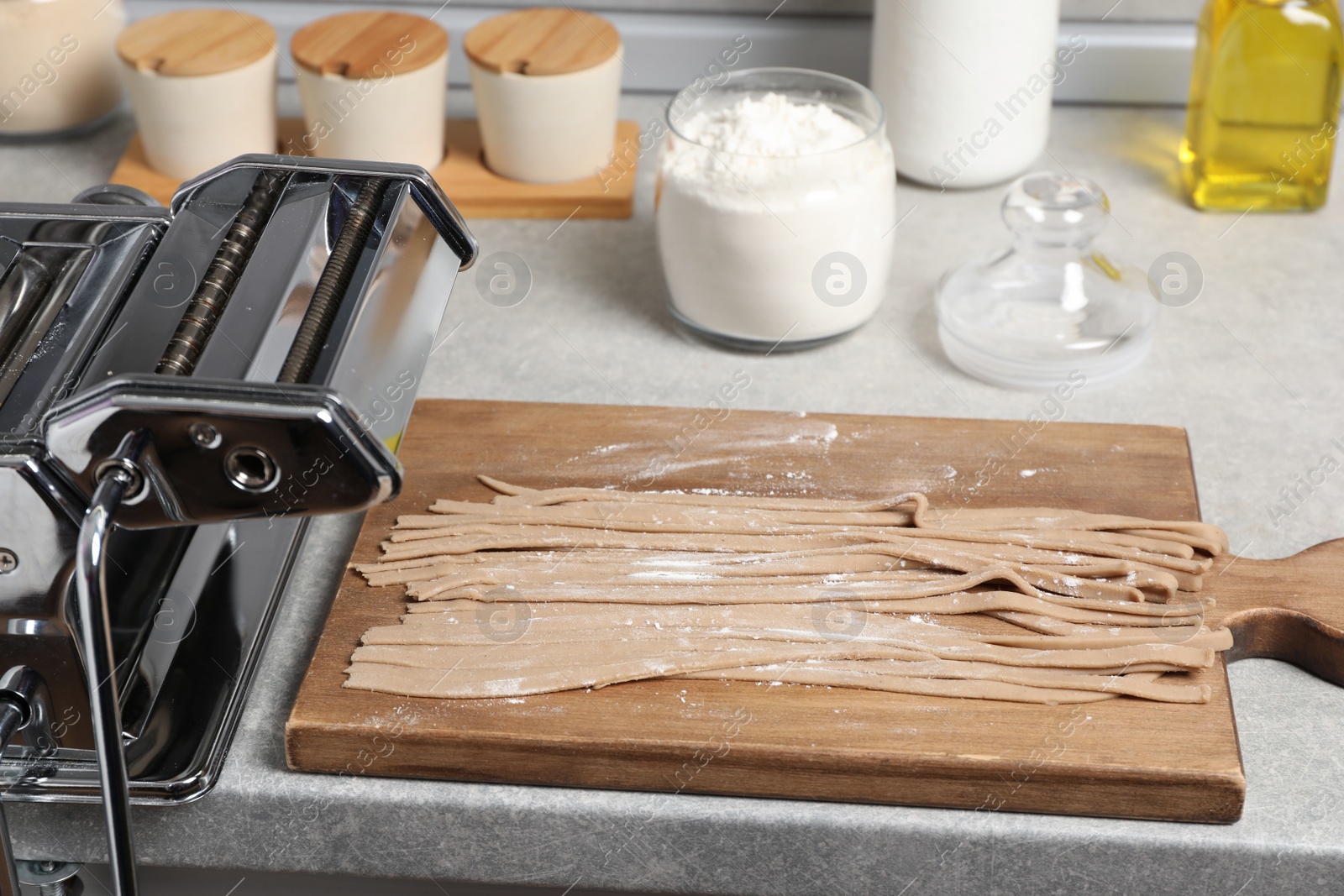 Photo of Uncooked homemade soba with pasta machine on table