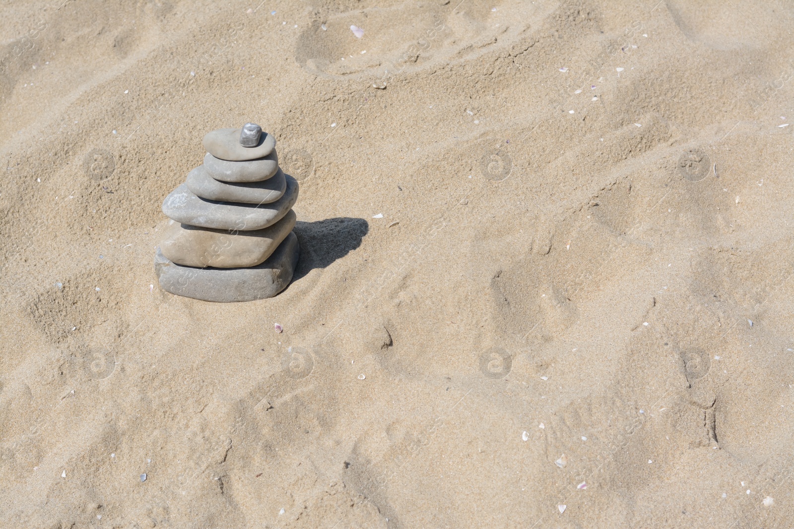 Photo of Stack of stones on beautiful sandy beach, space for text