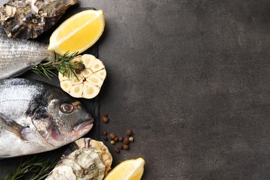 Photo of Flat lay composition with fresh raw dorado fish, oysters and lemon on grey table. Space for text